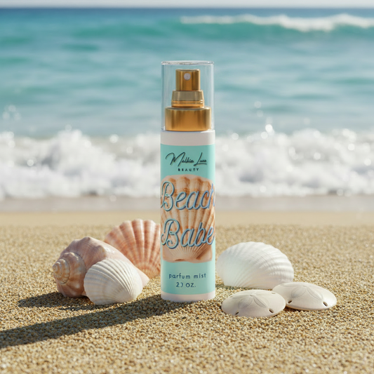 Product label for 'Beach Babe' parfum mist by Malkia Luxe Beauty with a shell design on a light blue background.